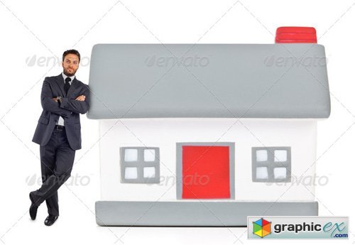 Businessman leaning against a miniature house - Photodune